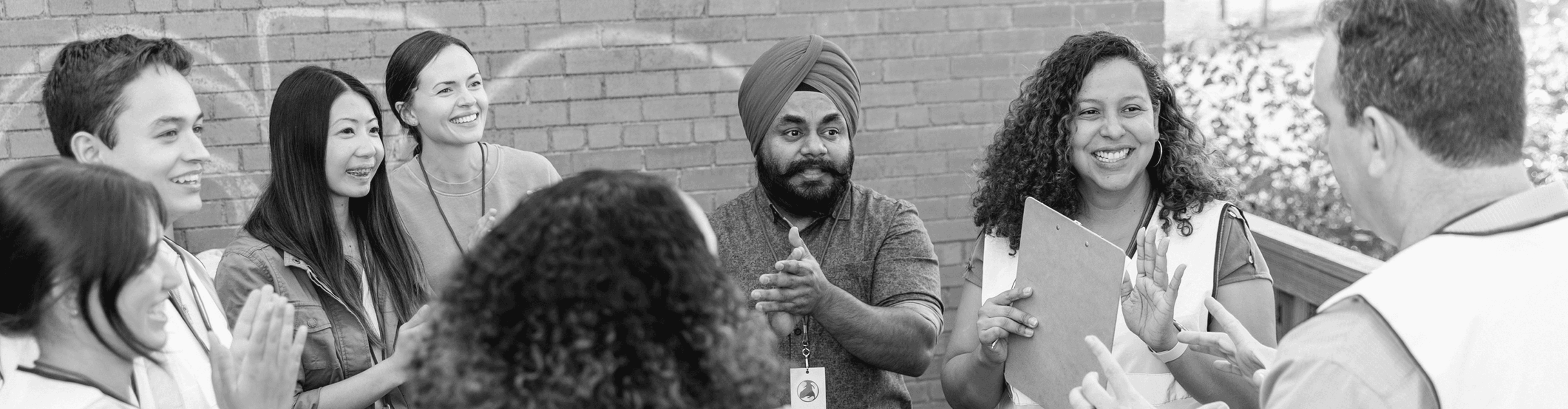 A team of volunteers conversing in a huddle while smiling